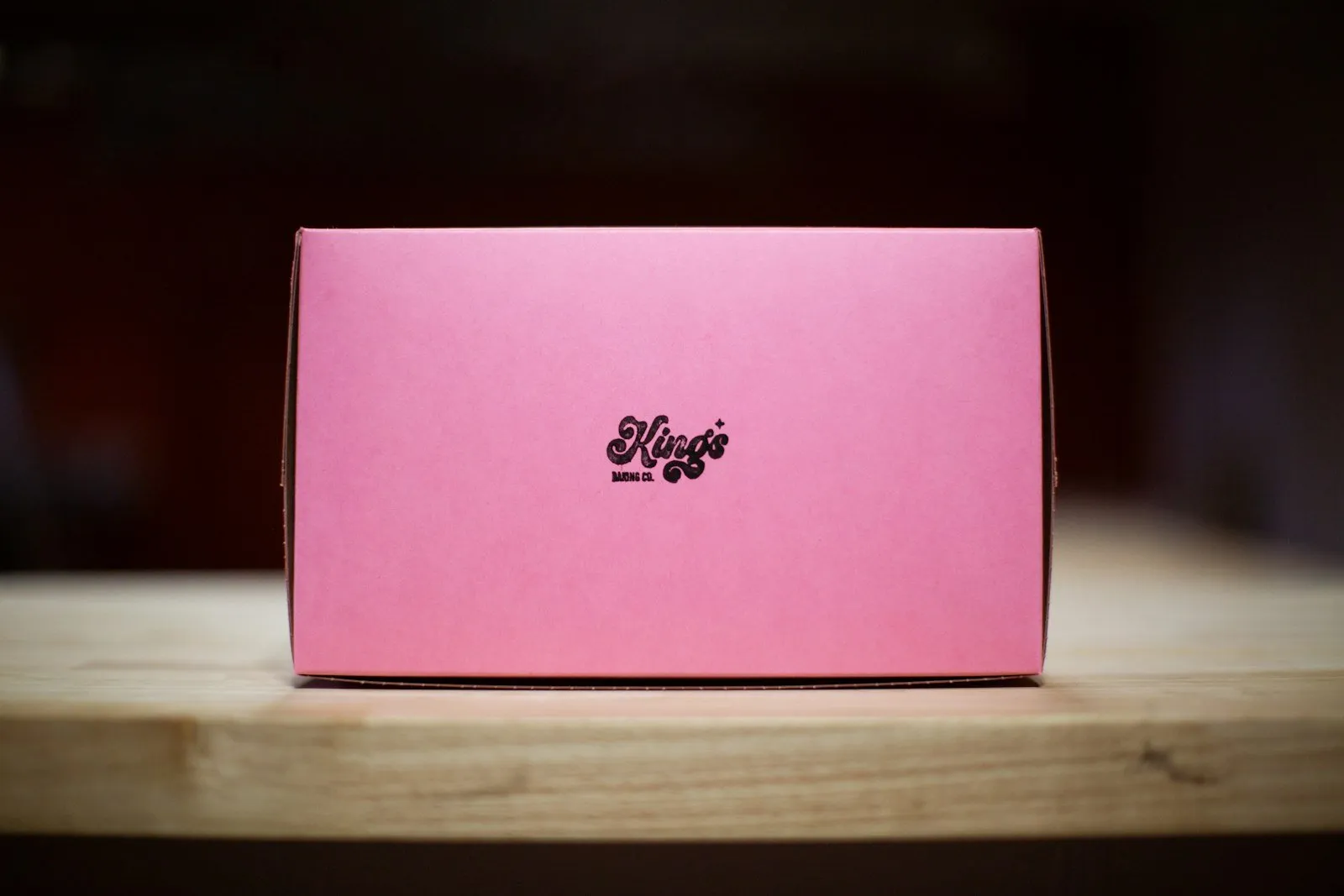 Pink gift box on a wooden table